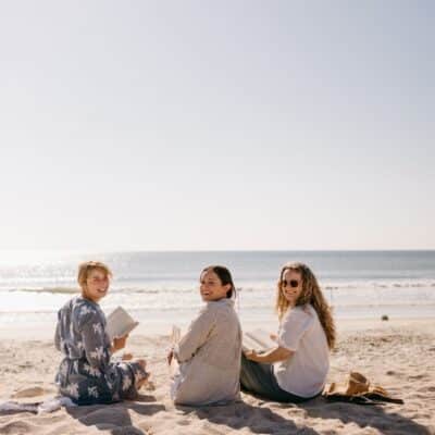 3 young women on the beach looking at the camera