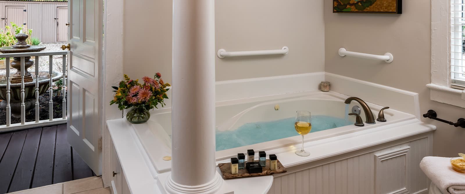 Bathroom with white walls, tiled flooring, and jetted tub