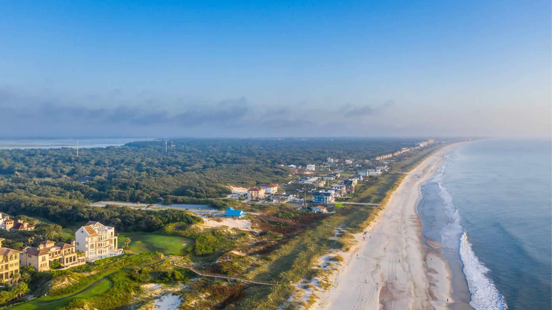 Aerial view of a beach with multiple homes and trees