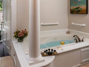 Bathroom with white walls, tiled flooring, and jetted tub