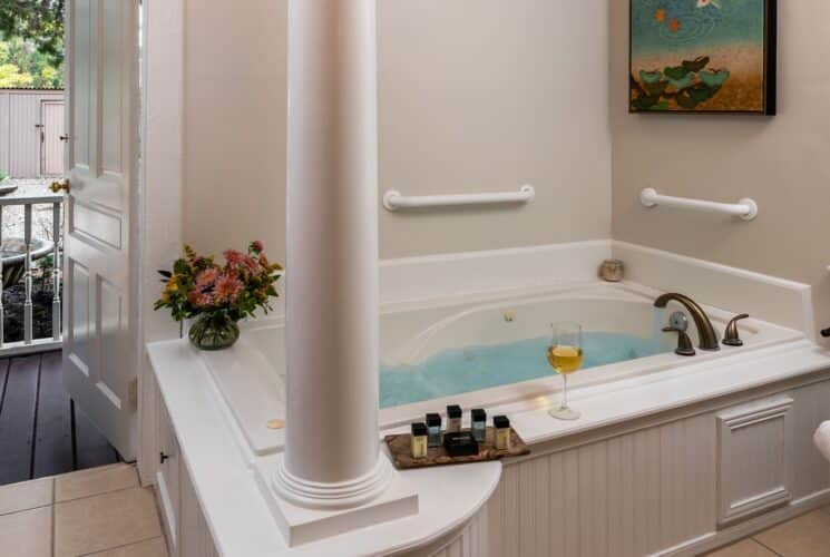 Bathroom with white walls, tiled flooring, and jetted tub