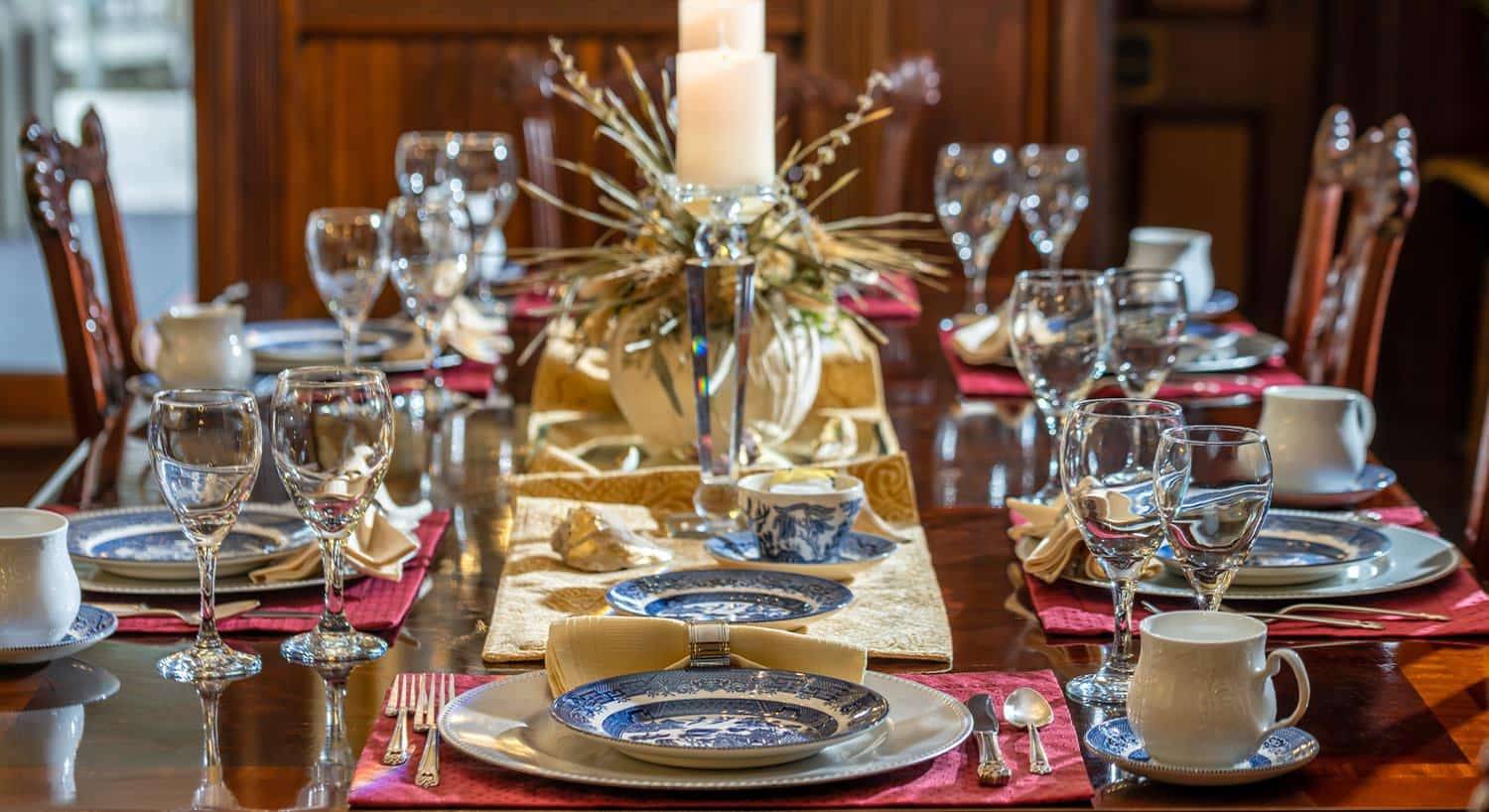 Close up view of dark wooden dining table with multiple placesettings